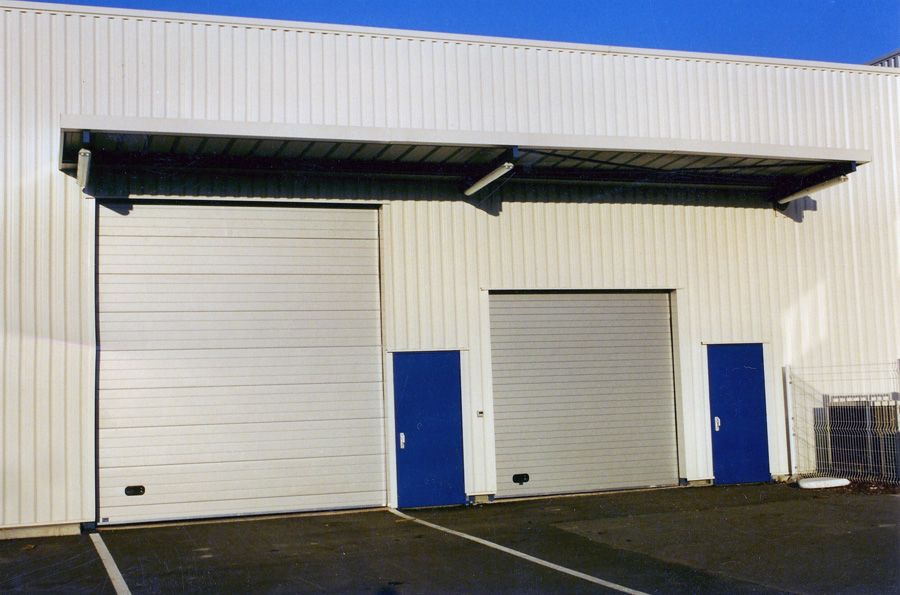 Grande et petite portes sectionnelles isolées grises pour l’industrie et le commerce.