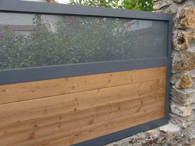 Portail nature sur-mesure marron en aluminium et en bois ajouré et transparent pour les particuliers.