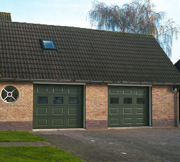 Habitat cassette laqué avec double porte de garage sectionnelle verte et ajourée de trois fenêtres pour les particuliers avec contours en briques.
