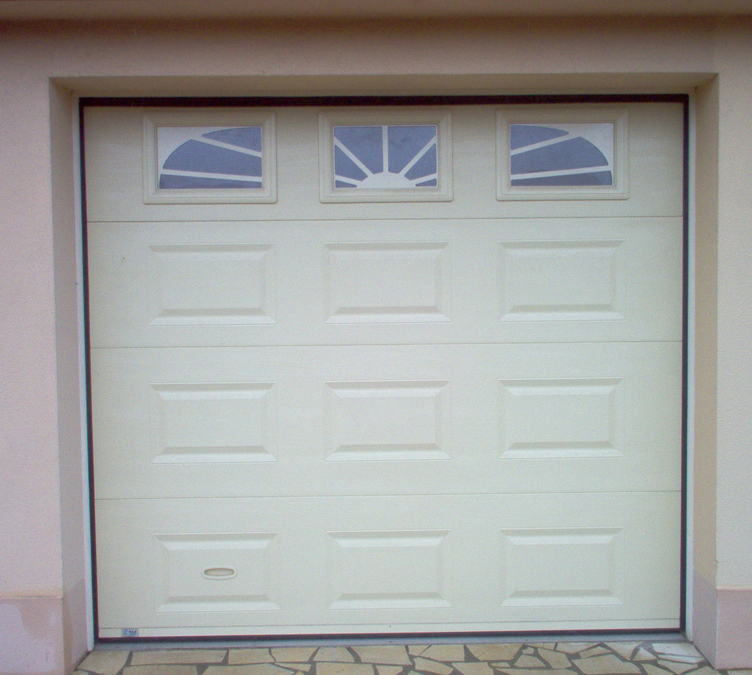 Détail de l’habitat cassette laqué sur mesure avec porte de garage sectionnelle blanche pour les particuliers avec trois fenêtres ajourées.