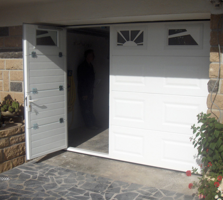 Habitat cassette portillon avec porte de garage sectionnelle ouverte blanche en pvc pour les particuliers avec trois fenêtres ajourée.