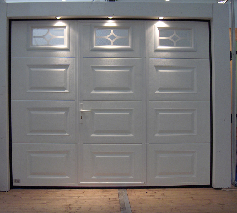 Habitat cassette portillon avec porte de garage sectionnelle blanche éclairée en pvc et trois fenêtres ajourées pour les particuliers.