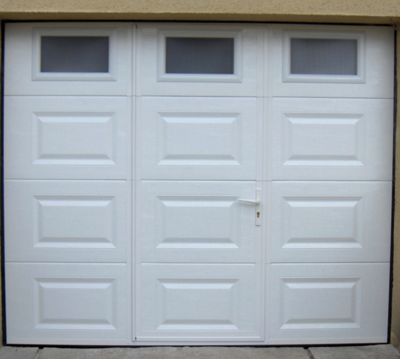Habitat avec neuf cassettes portillon avec porte de garage sectionnelle blanche en pvc et trois fenêtres opaques pour les particuliers.