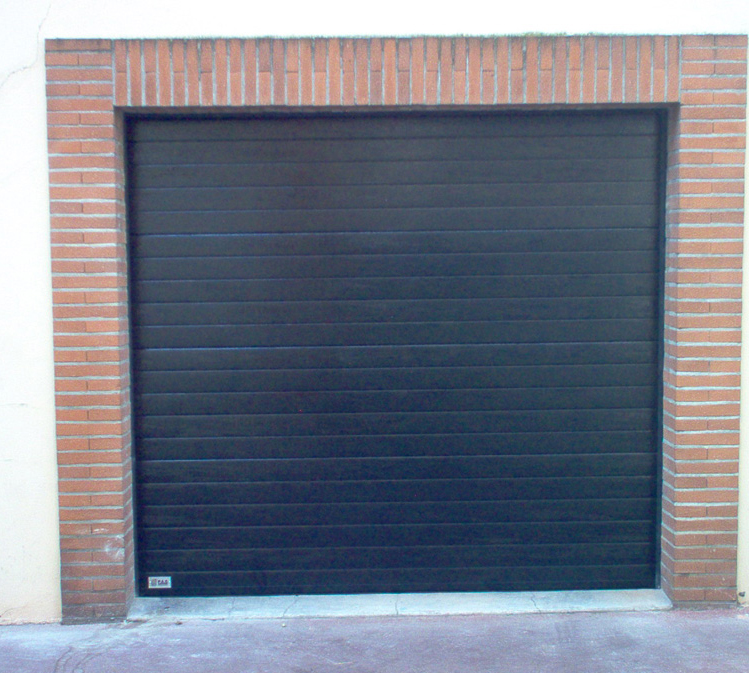Habitat cassette nervuré avec petite porte de garage sectionnelle noire aux contours en brique.