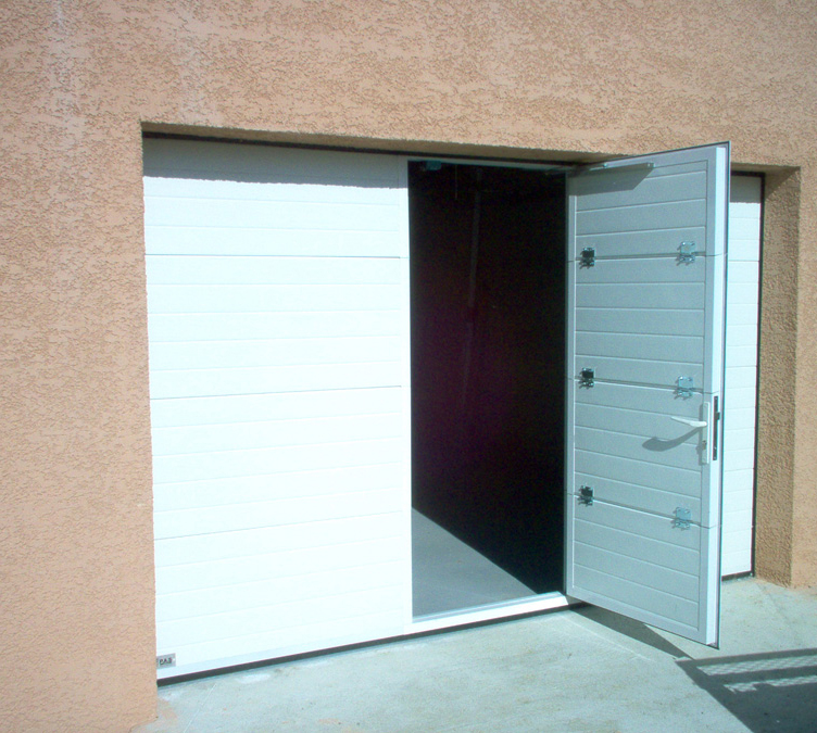Habitat cassette nervuré à portillon avec porte de garage sectionnelle blanche ouverte.